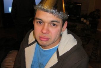 A picture of Aaron Frescas looking sad in a party hat
